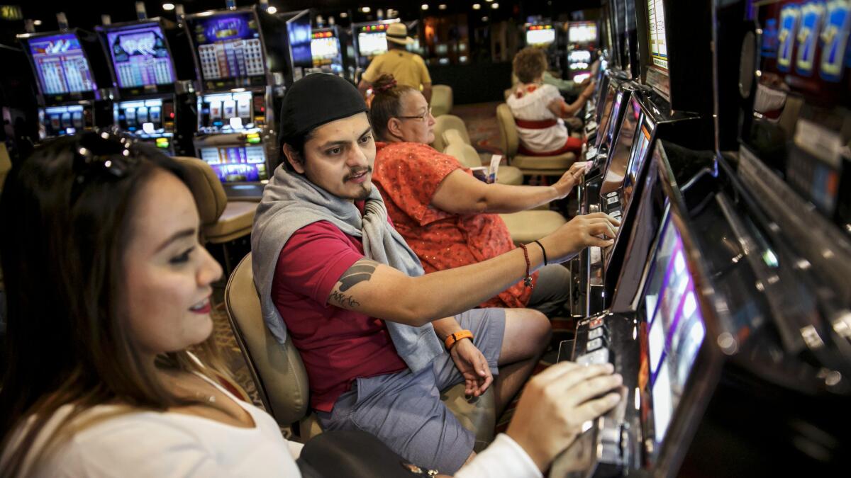 Hector Sandovar and Emma Alvarez, from Mexico, try out the coin slot machines for the first time at Circus Circus Hotel & Casino in Las Vegas.