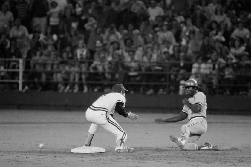 Lou Brock of the St. Louis Cardinals starts his slide into second base as he sets the record for stolen bases at 893, in San Diego, Calf., Aug. 29, 1977. Shortstop Bill Allmon of the San Diego Padres waits for the ball. (AP Photo/Lennox McLendon)