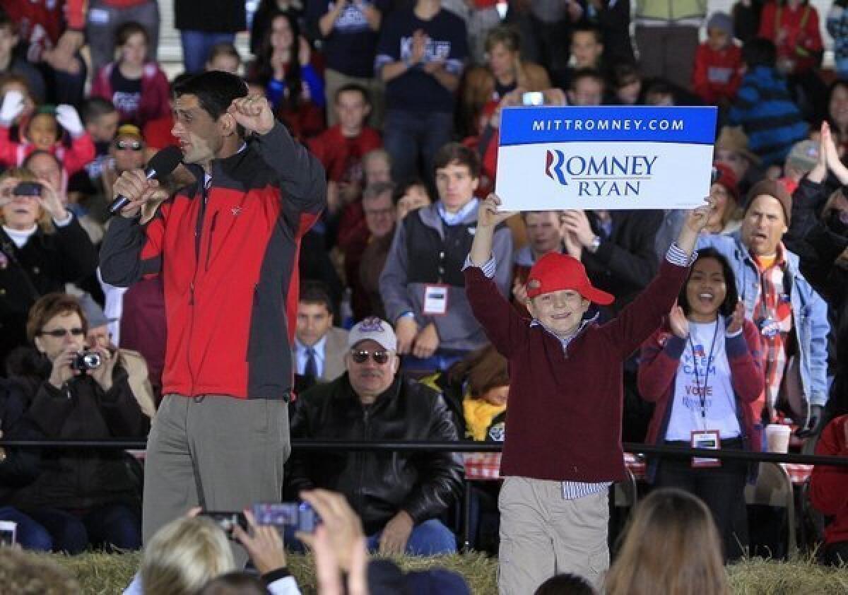 Republican vice presidential candidate Paul Ryan speaks during a campaign stop in Yellow Springs, Ohio, as his son Charlie jumps on stage with a sign.