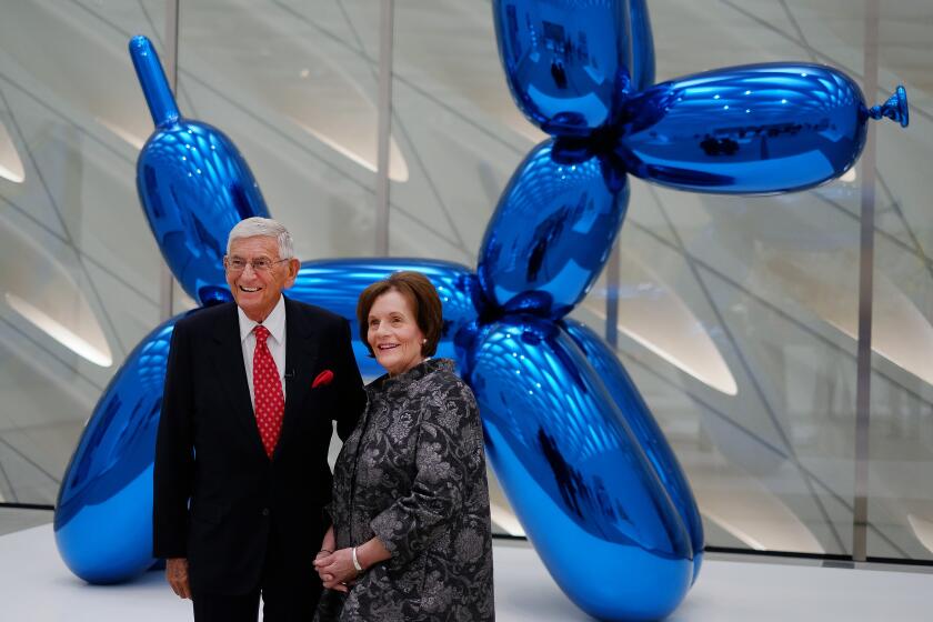 Eli Broad and his wife Edythe in front of the Jeff Koons sculpture "Balloon Dog (Blue)" at the opening of the Broad in 2015. 