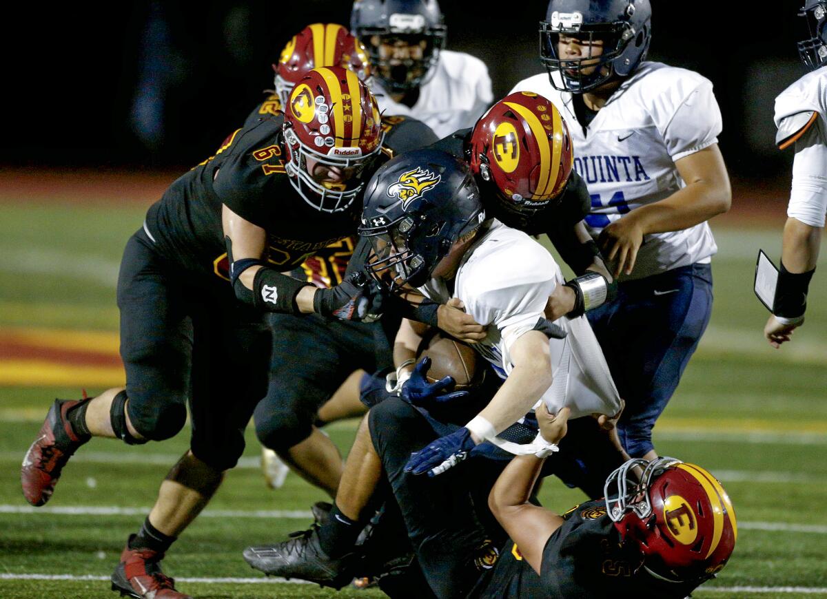 Estancia's Ryan Carrasco (67), Jorge Cortinas, and Jose Anguiano (55) bring down La Quinta running back Cooper Starnes.