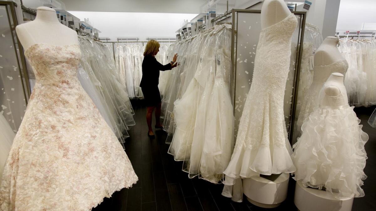 A David's Bridal store manager looks for gowns for customers to try on in Los Angeles in 2014.