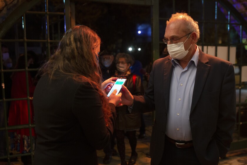 A man in Jerusalem presents his "green passport," proof that he is vaccinated against the coronavirus.