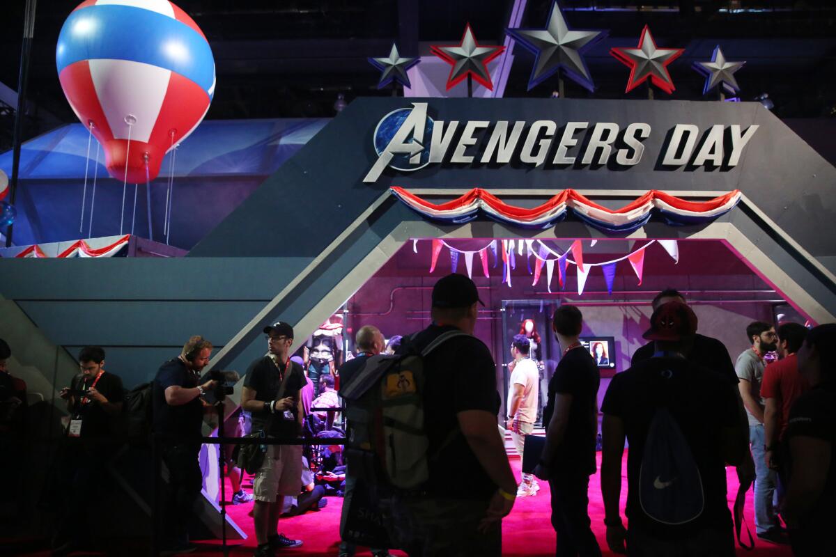 People pass the Avengers Day exhibit during E3.