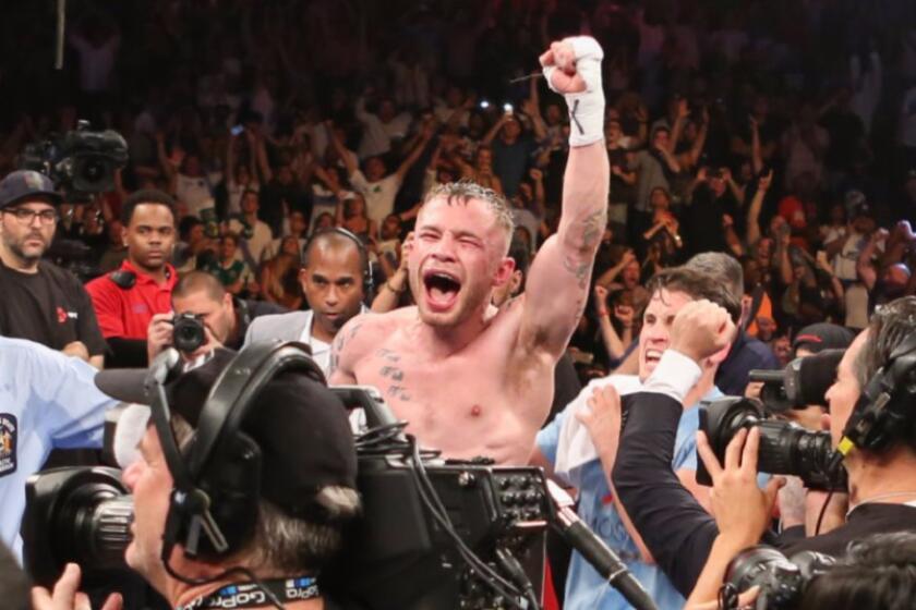 Carl Frampton celebrates after his win by decision over Leo Santa Cruz for the WBA featherweight title on July 30.