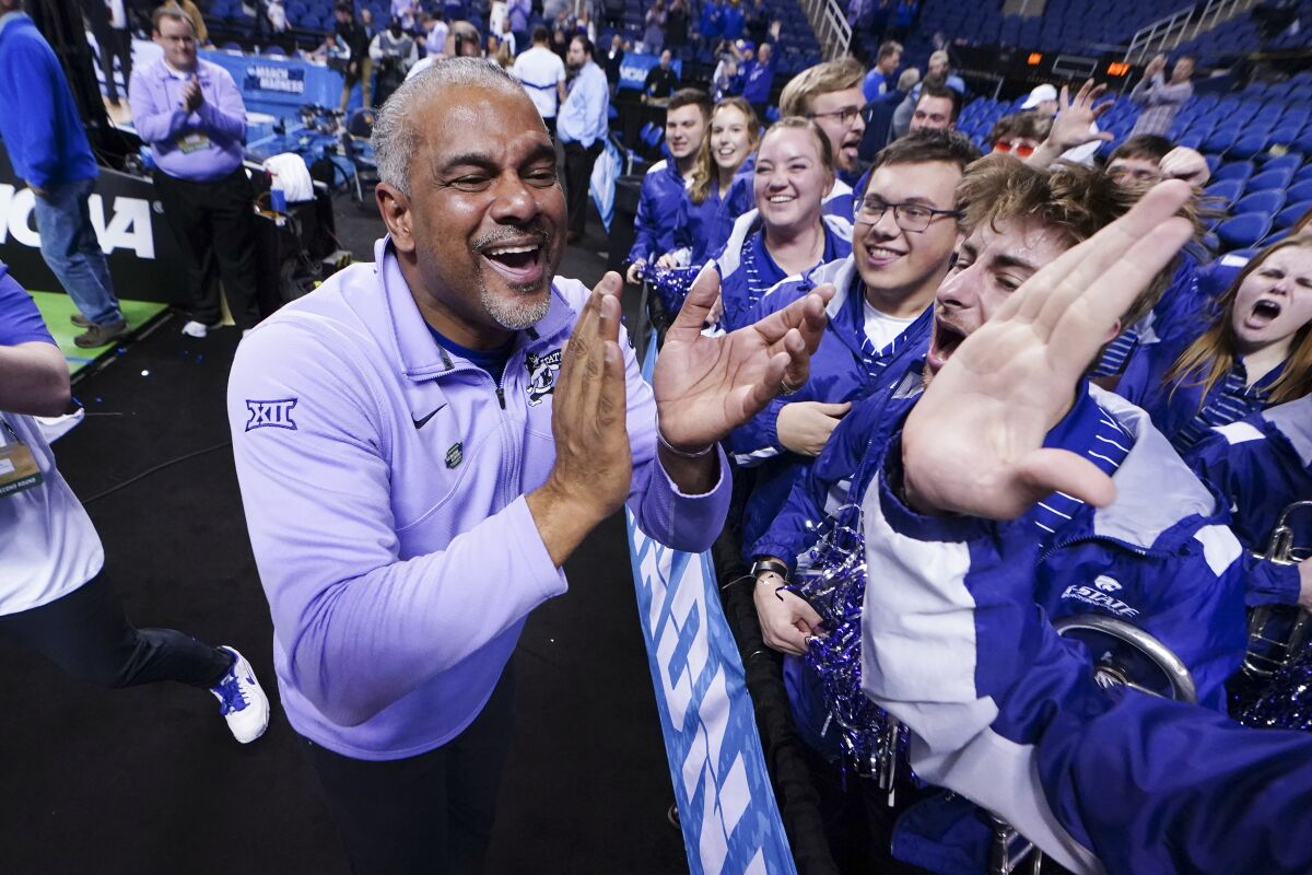 Kansas State head coach Jerome Tang celebrates with members of the pep band after defeating Kentucky in a second-round college basketball game in the NCAA Tournament on Sunday, March 19, 2023, in Greensboro, N.C. (AP Photo/John Bazemore)
