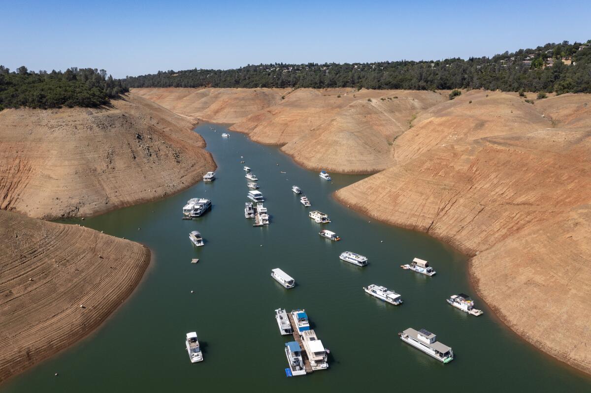 Boats are moored in a shrinking arm of Lake Oroville last summer.