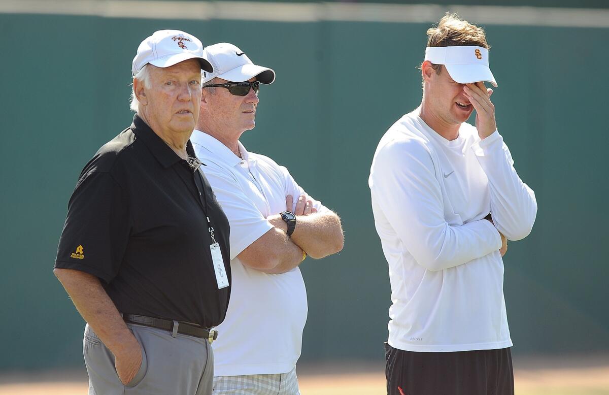 Former USC coach John Robinson, left, watches a USC practice session with ex-Cal coach Jeff Tedford, center, and recently fired USC coach Lane Kiffin in August. Kiffin wasn't known for taking Robinson's advice.