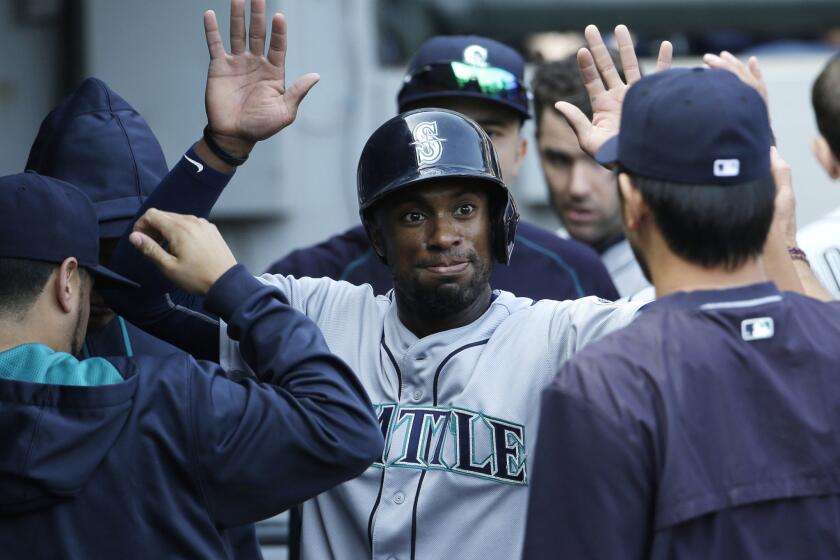 Mariners outfielder Austin Jackson celebrates with teammates after scoring on a single by Kyle Seager during a game against the White Sox on Aug. 30, 2015.