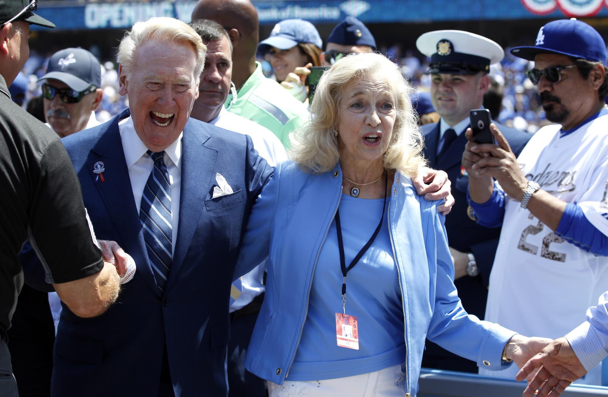 Dodgers broadcaster Vin Scully, left, and his wife, Sandra Scully, walk off the field.