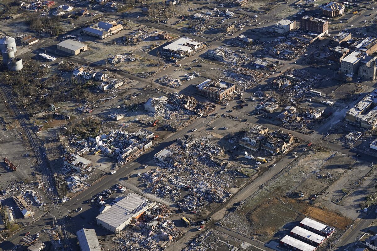 In this aerial photo, a collapsed factory and surrounding areas are seen in Mayfield, Ky., Sunday, Dec. 12, 2021. Tornadoes and severe weather caused catastrophic damage across multiple states Friday, killing several people overnight. (AP Photo/Gerald Herbert)