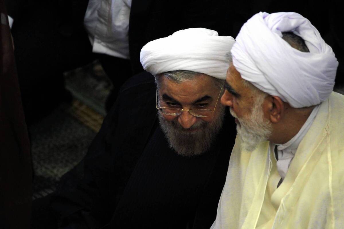 Iranian President-elect Hassan Rouhani, left, listens to a worshiper as they attend Friday prayers in Tehran. Some former top U.S. officials and foreign diplomats want the Obama administration to reach out to Iran to end the nuclear stalemate, but some analysts note that could spark a backlash from U.S. conservatives who think Rouhani is less moderate than he seems.