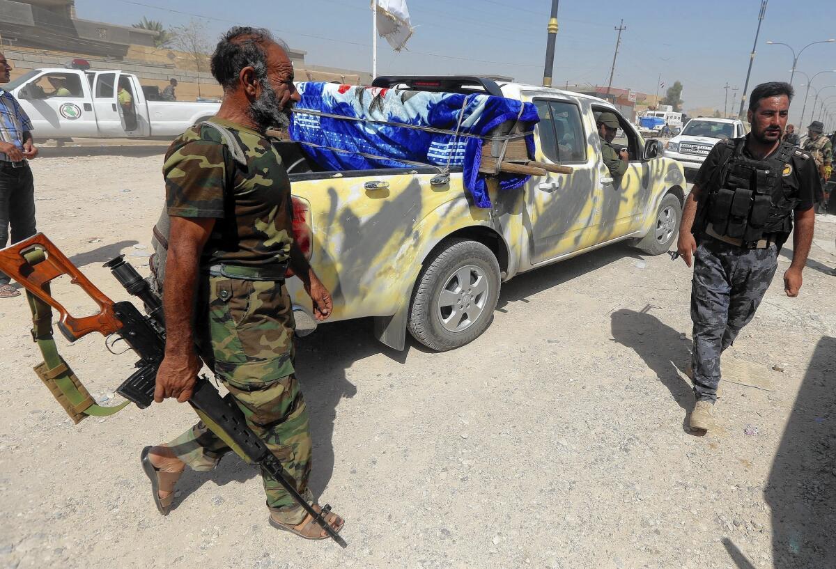 The coffin of an Iraqi Shiite militia fighter is transported on the outskirts of Amerli. Over the weekend, U.S. airstrikes on Islamic State strongholds and a ground offensive by Iraqi toops, including Kurds, helped break a siege of the town.