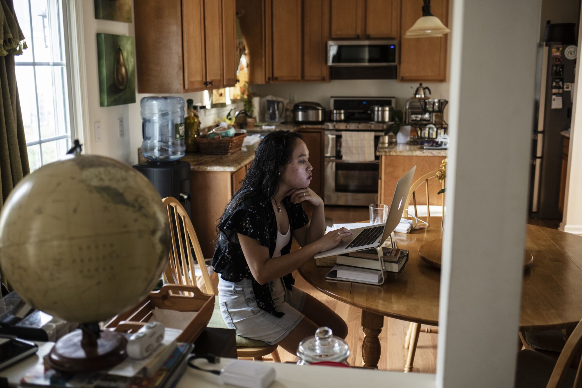 Sophia Sumaray searches for an apartment in San Diego in her parents' home in Franklin Park, N.J., on Wednesday.