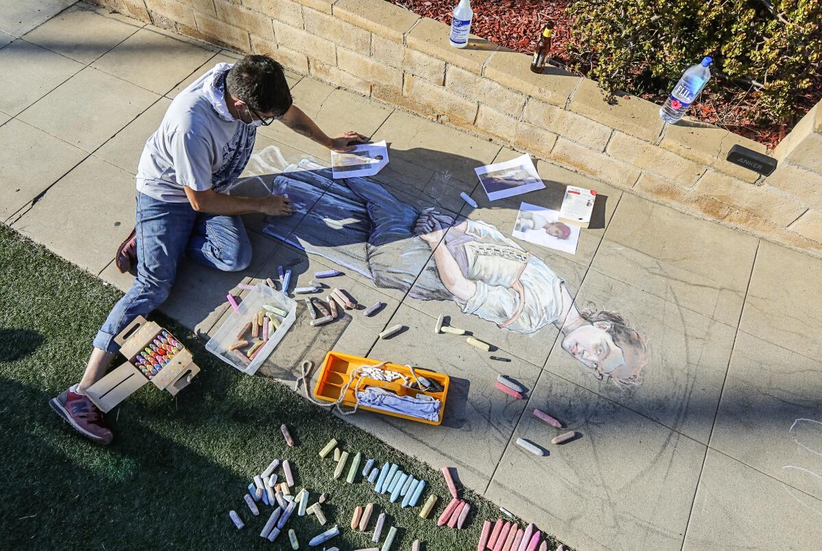 Artist Erick Toussaint works on one of his chalk art creations outside his Ocean Beach home.