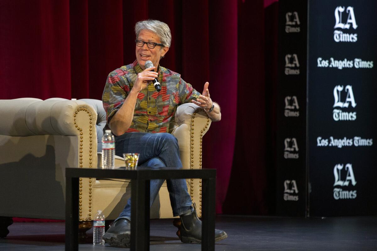 Jonathan Franzen holds a microphone while talking about his novel  onstage at the Los Angeles Times Festival of Books.
