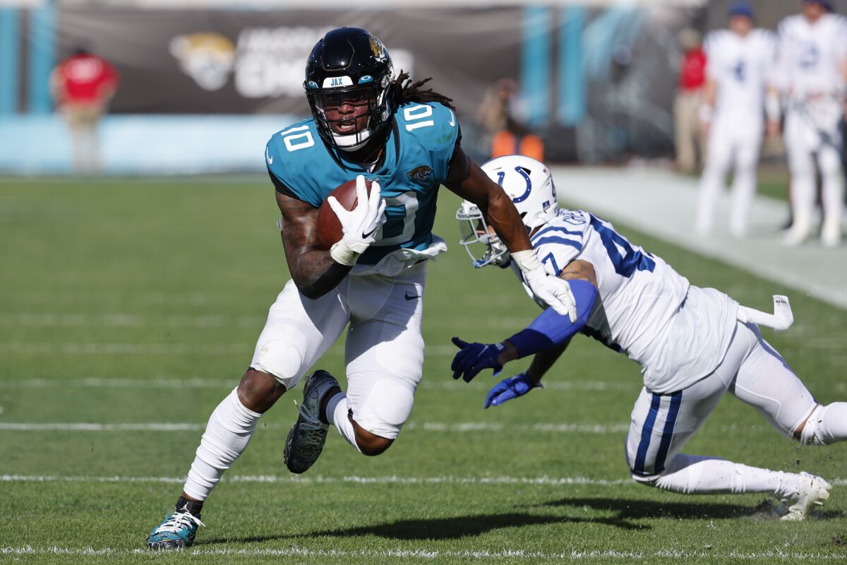Jacksonville Jaguars wide receiver Laviska Shenault Jr. avoids Indianapolis Colts cornerback Anthony Chesley.