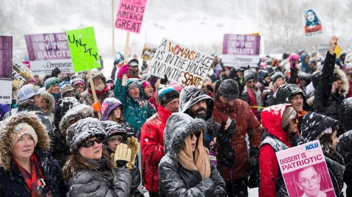 People hold signs and cheer at City Park for the Respect Rally event during the 2018 Sundance Film Festival on January 20, 2018 in Park City, Utah.