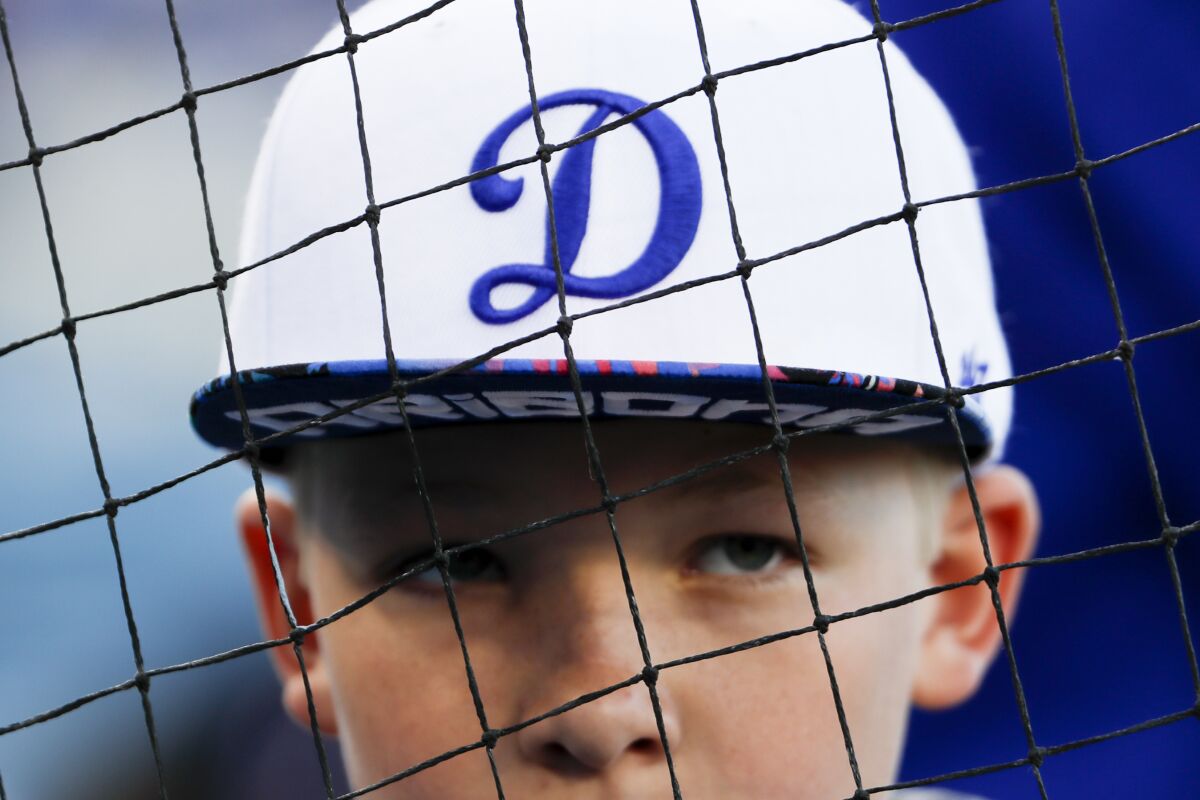 A young Dodgers fan watches players warm up before the game.