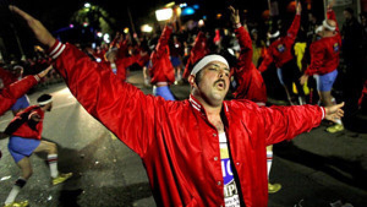 Daryl McGill of the 610 Stompers, an all-male marching club, dances with fellow members while marching with the Krewe of Nyx in New Orleans.