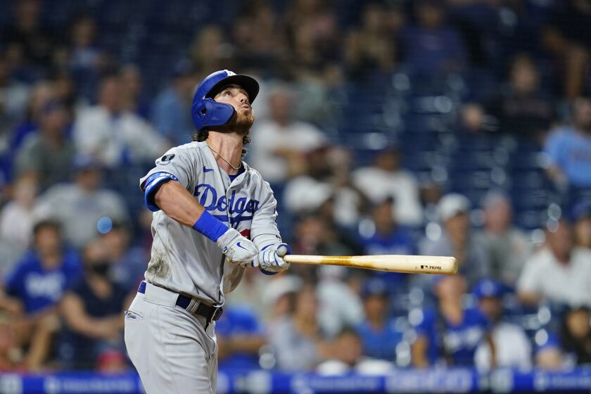 Los Angeles Dodgers' Cody Bellinger watches after hitting a two-run home run against Philadelphia Phillies relief pitcher Mauricio Llovera during the ninth inning of a baseball game, Wednesday, Aug. 11, 2021, in Philadelphia. (AP Photo/Matt Slocum)