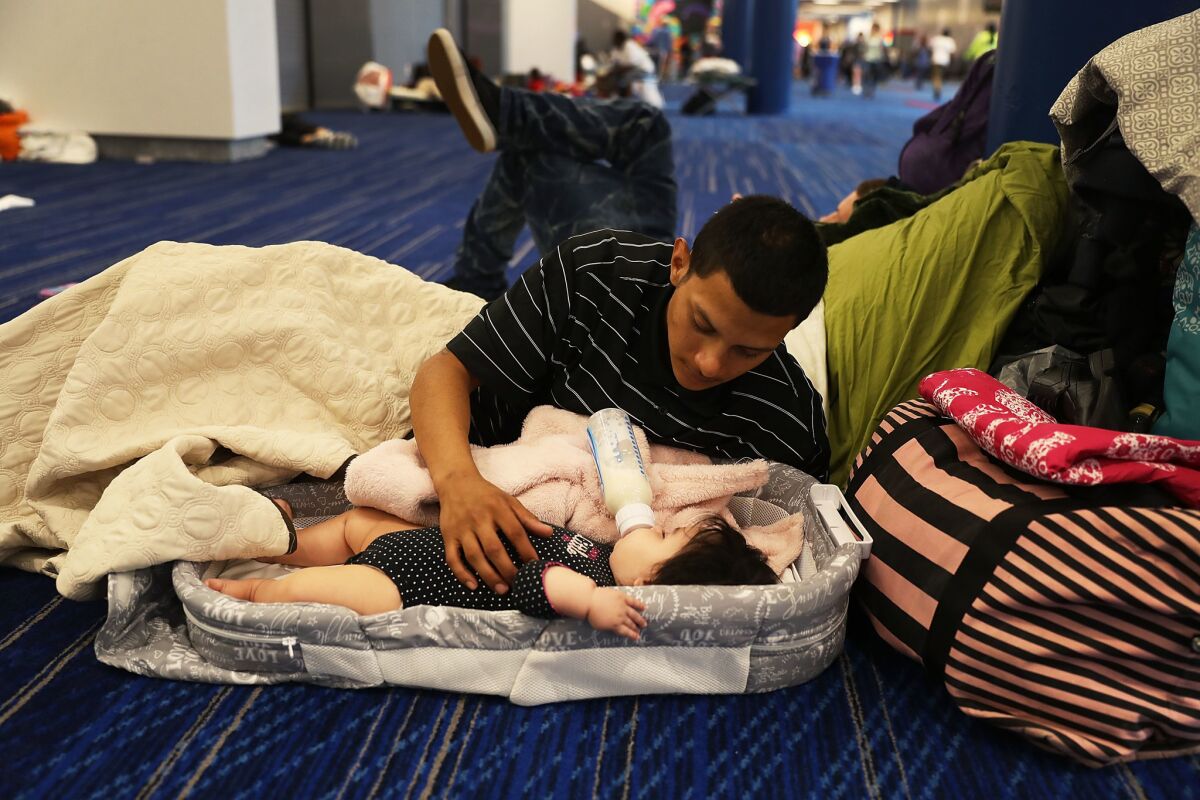 Mark Ocosta and his baby, Aubrey, take shelter at the George R. Brown Convention Center. (Joe Raedle / Getty Images)