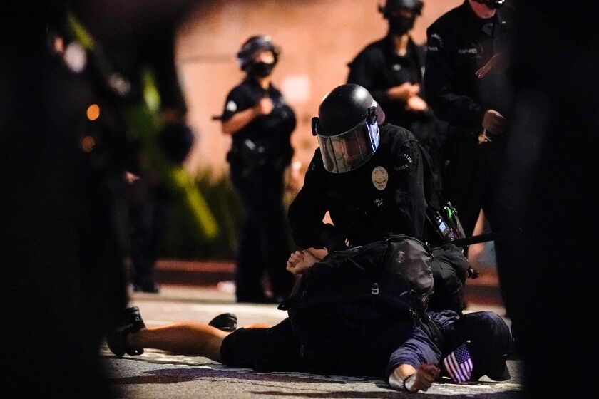 LOS ANGELES, CA - May. 29,: Protestors, outraged over the the death of George Floyd, a black man killed after a white Minneapolis police officer pinned him to the ground with his knee, in on Friday, May. 29, 2020 in Los Angeles, CA. (Kent Nishimura / Los Angeles Times)