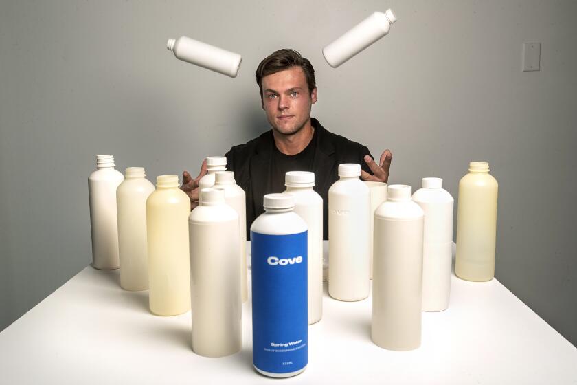 CULVER CITY, CA - OCTOBER 02, 2020: Alex Totterman, CEO and founder of Cove Water in Culver City, is photographed with a mix of prototype and actual plastic water bottles, as well as bottle caps and label that he says are made up entirely of biodegradable material. The company will begin selling the bottled water sometime in the fall. (Mel Melcon / Los Angeles Times)