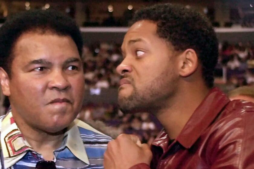 Actor Will Smith, right, jokes with boxing great Muhammad Ali before the start of the Shane Mosley-Oscar De La Hoya fight on June 17, 2000.