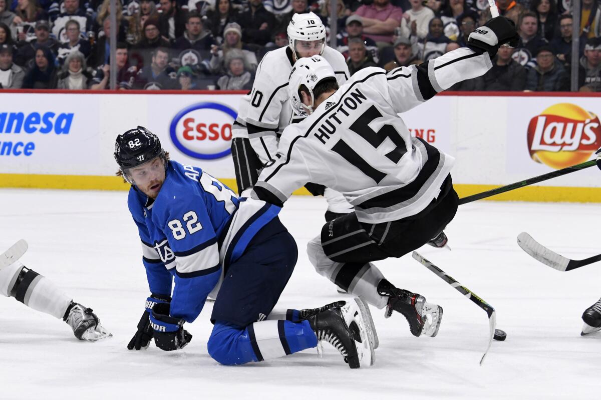Kings defenseman Ben Hutton (15) falls to the ice while battling with Jets forward Mason Appleton (82) during the second period of a game Feb. 18.