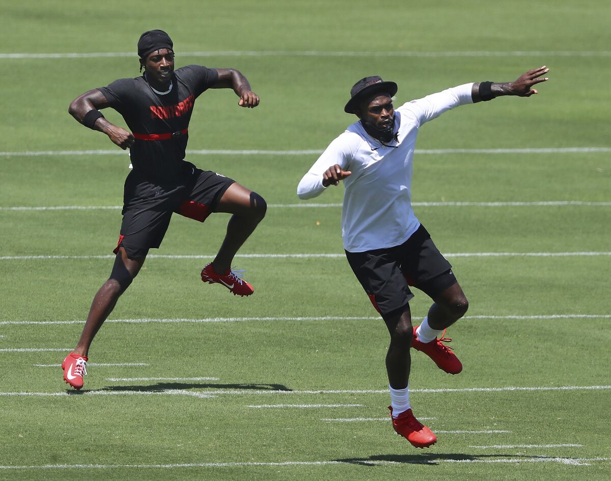 FILE - In this Aug. 4, 2020, file photo, Atlanta Falcons wide receivers Calvin Ridley, left, and Julio Jones work on a drill during a team strength and conditioning NFL football workout in Flowery Branch, Ga. It would be easy to overlook Calvin Ridley, being a receiver who plays on the same team as Julio Jones. Ridley, though, has other ideas. Heading into his third year with the Atlanta Falcons, he's planning on a breakout season and making sure everybody knows his name, too. (Curtis Compton/Atlanta Journal-Constitution via AP, File)