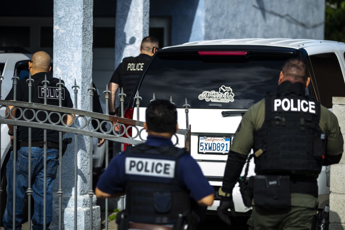 Immigration and Customs Enforcement fugitive operations team members converge on a house in Compton.