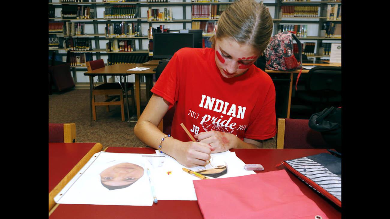 Sophomore Megan Knutson works on a portrait of a 13-year old Syrian refugee, for the Burroughs High School Portraits of Kindness project, at the school in Burbank on Friday, Nov. 3, 2017.