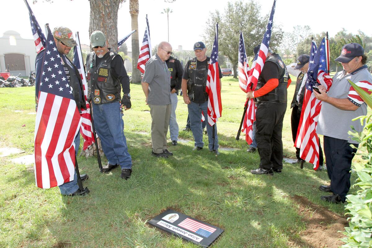 Patriot Guard riders stand next to covered plaque that was unveiled at the unmarked grave site for Glendale resident and US Army PFC Allan J. Altieri 50 years to the day after he was killed in Vietnam, at San Fernando Mission Cemetery in Mission Hills on Friday, June 24, 2016.