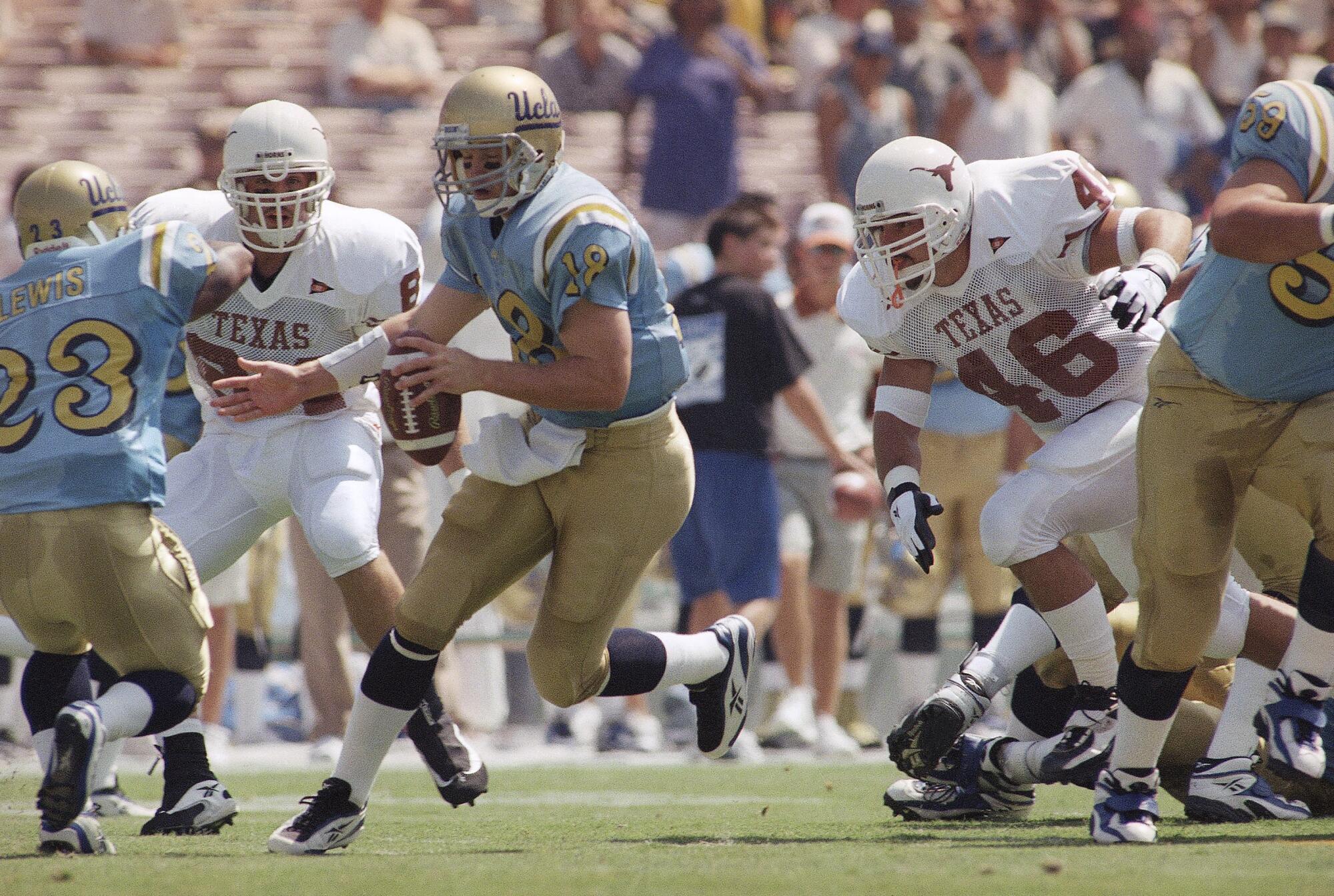 UCLA oyun kurucusu Cade McNown, 12 Eylül 1998'deki bir maç sırasında Teksaslı Dusty Renfro (46) ve JJ Kelly (84) tarafından kovalanıyor.