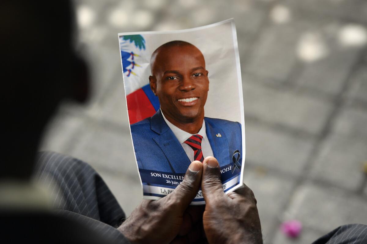 A person holds a photo of late Haitian President Jovenel Moïse.