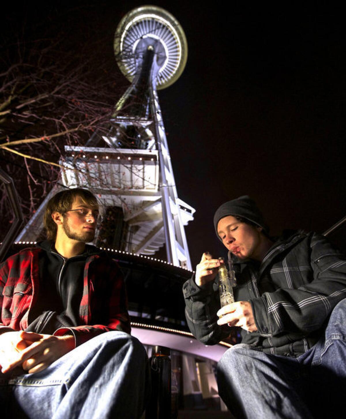 Dustin, left, and Paul of Tacoma, Wash., both of whom declined to give their last names, share a water pipe beneath the Seattle Space Needle the day a law legalizing the recreational use of marijuana took effect on Dec. 6, 2012.