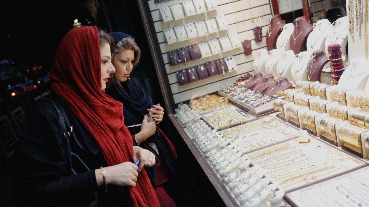 Iranian women peer in the window of a jewelry shop in Tehran.