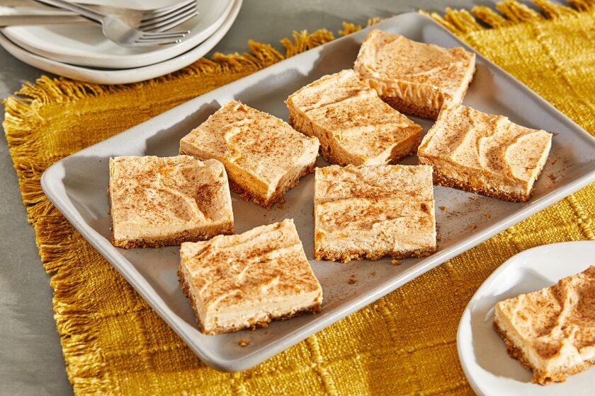 Pumpkin cheesecake bars ready to serve on a platter.