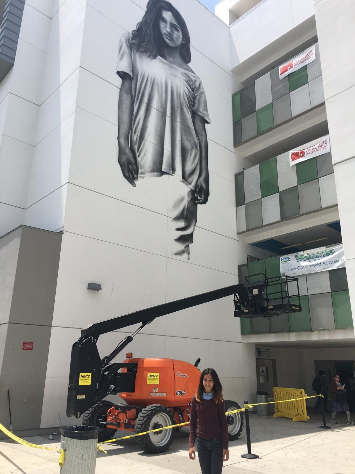 Jessica Miramontes in front of her mural portrait by Cyrcle.