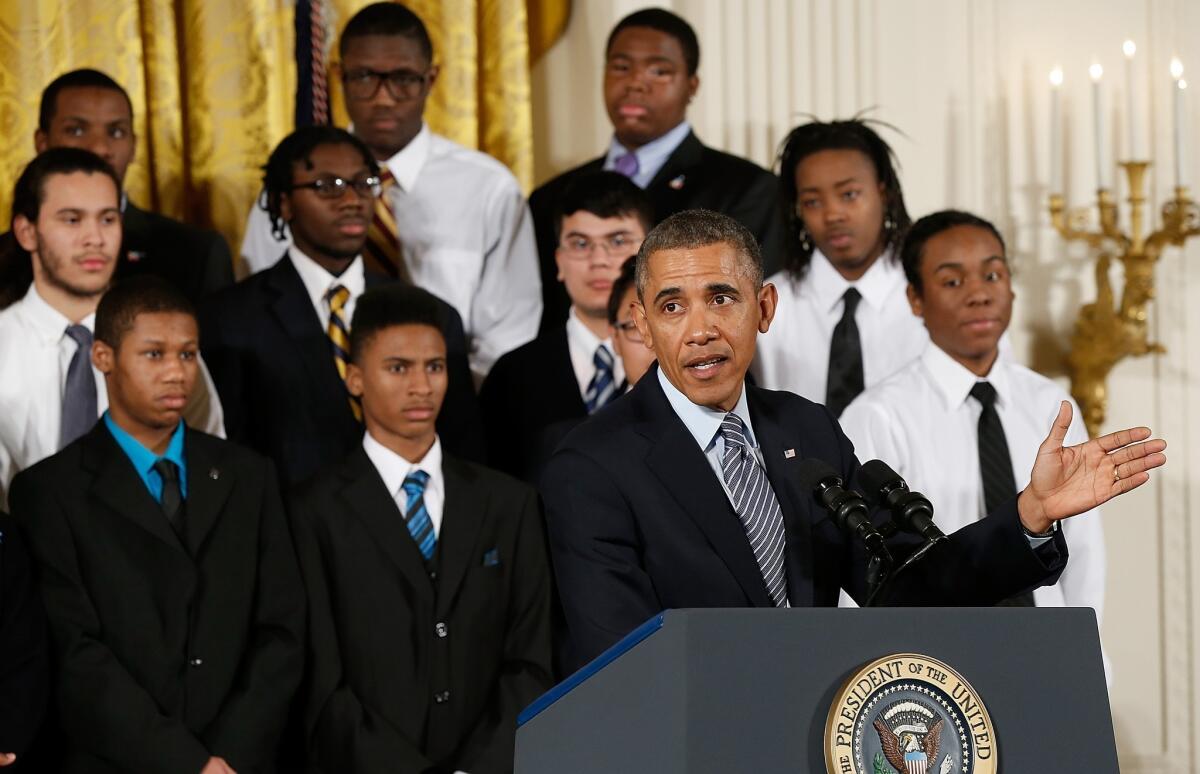President Obama speaks as young men who participate in the "Becoming A Man" program in Chicago watch during an event in the East Room of the White House. Obama signed an executive memorandum following remarks on the "My Brother's Keeper" initiative.