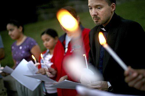 The Rev. Howard Dotson leads a candlelight vigil for Moses Salinas, a 23-year-old who was gunned down in Angelino Heights in November. Dotson is part of the police-sponsored Rampart Clergy Council, which pledges to hold a prayerful service for each homicide victim in the Rampart Division. There have been 11 vigils in the last three months.