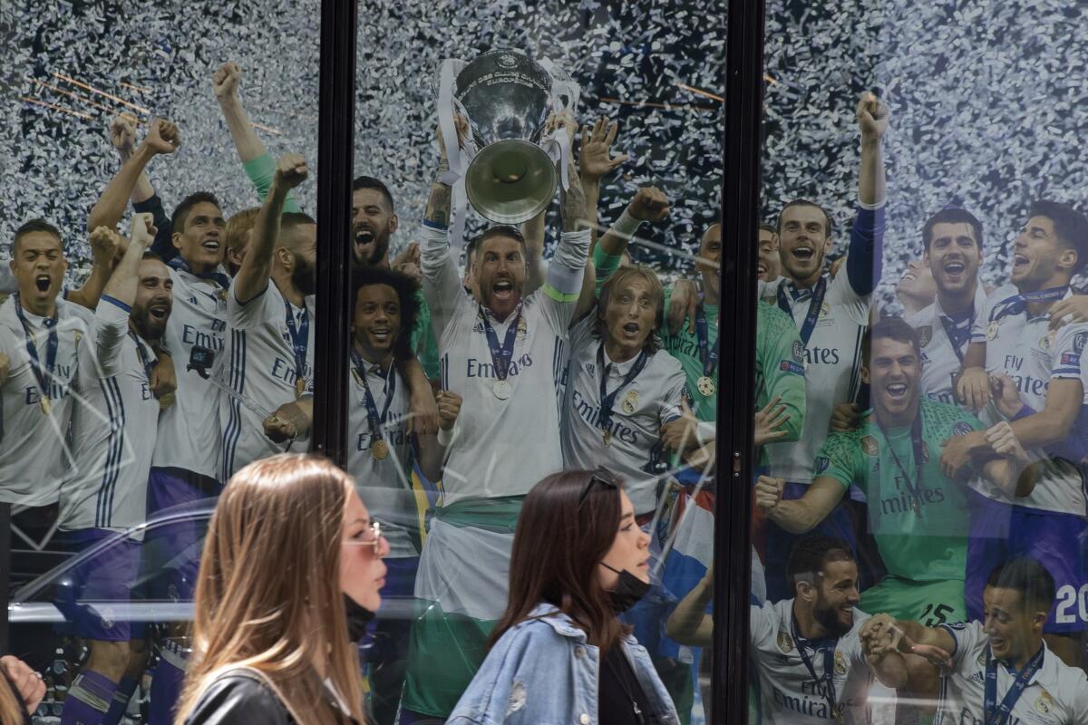 Dos mujeres pasan frente a un afiche del Real Madrid 