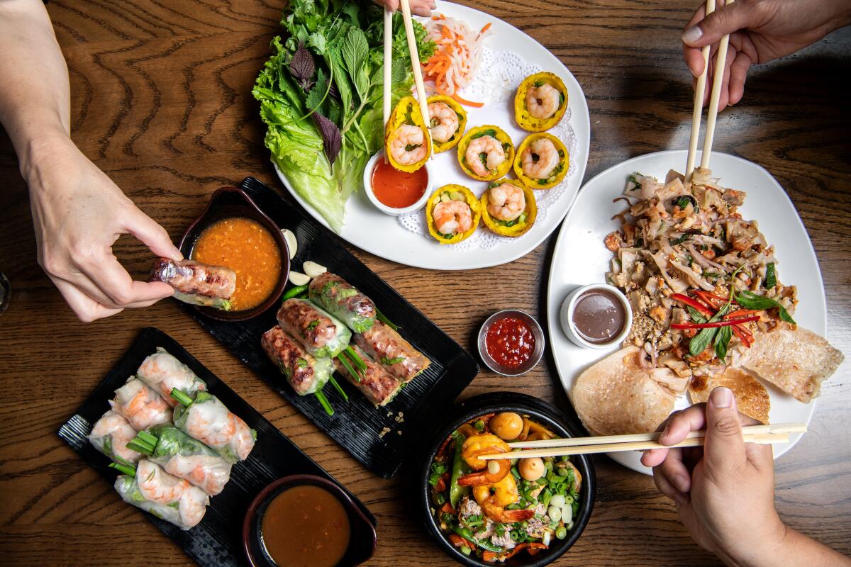 Grilled pork spring rolls; luna cakes with shrimp; jackfruit salad; and seafood hot pot at Brodard in Fountain Valley