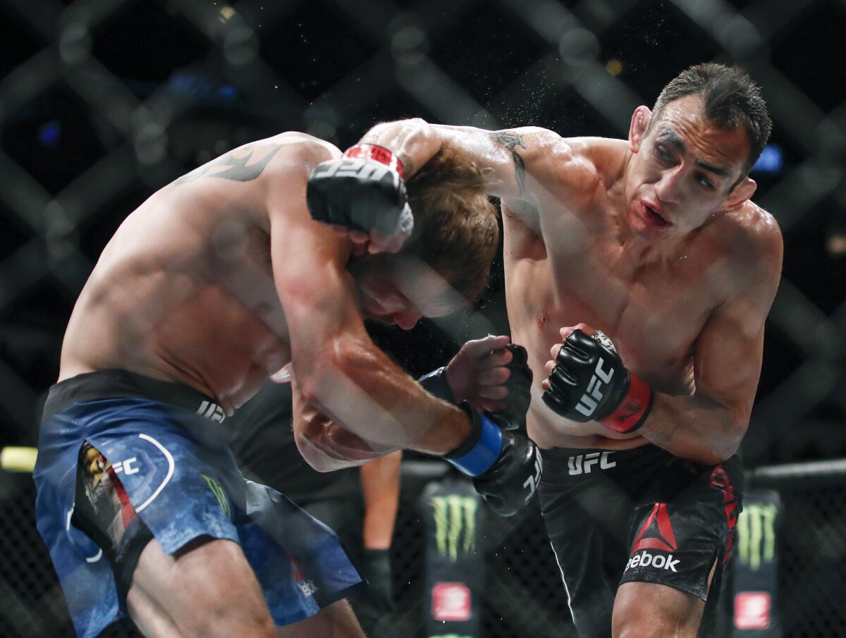 Tony Ferguson delivers a blow to Donald Cerrone during a lightweight fight at UFC 238 in Chicago on June 8, 2019.