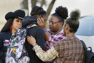 FILE - Darryl George, center left, a 17-year-old junior, and his mother Darresha George, center right, share words of encouragement before walking across the street to go into Barbers Hill High School after Darryl served a 5-day in-school suspension for not cutting his hair Monday, Sept. 18, 2023, in Mont Belvieu. George began attending a disciplinary program this week away from his classmates and regular teachers. He said in an interview with The Associated Press that he has felt isolated from and discouraged about not being able to play football or be more involved in campus events.(AP Photo/Michael Wyke, File)