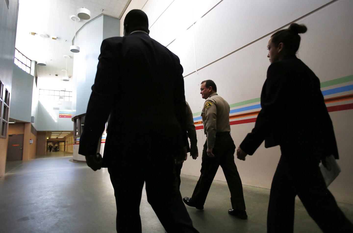 Los Angeles County Sheriff Jim McDonnell is escorted by his drivers Sgt. Clipper Hackett, left, and Deputy Janine Hanson, right, at the North County Correctional Facility in Castaic.