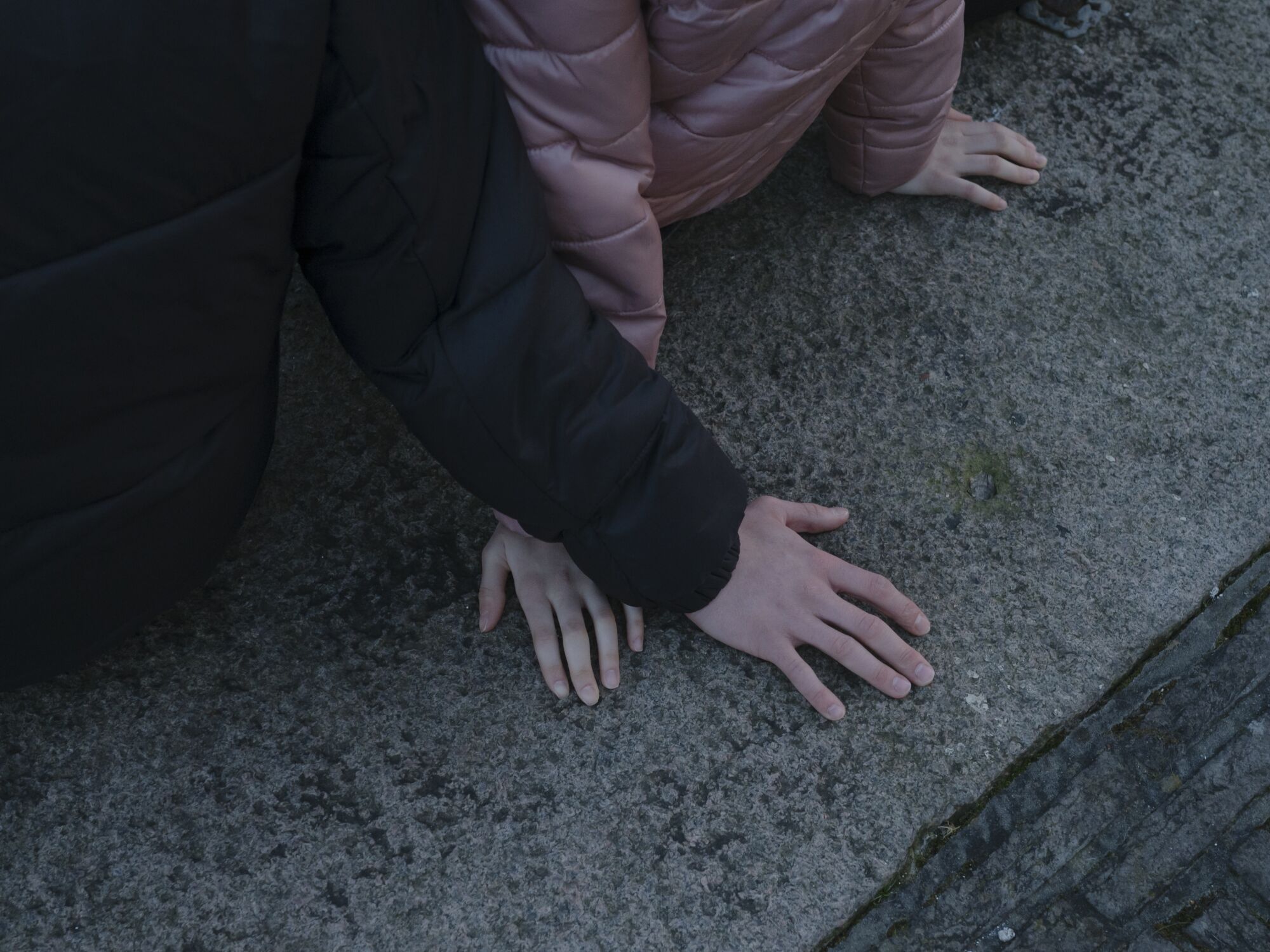 Hands rest on a concrete ledge 