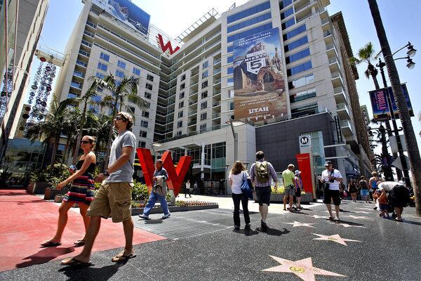People stroll along the Hollywood Walk of Fame in front of the ritzy Residences at W Hollywood.