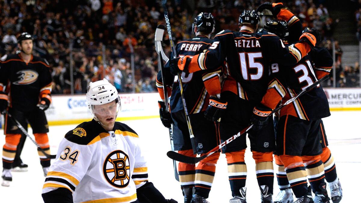 Boston Bruins forward Carl Soderberg, left, reacts as the Ducks celebrate a goal by forward Matt Beleskey during the third period of the Ducks' 3-2 win at Honda Center on Monday.